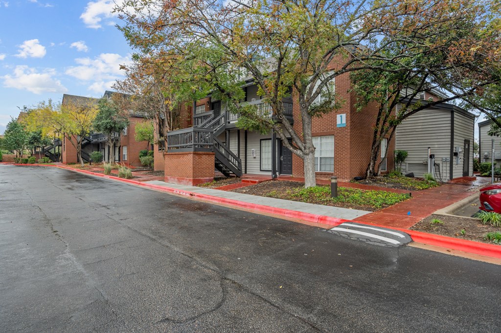 an empty street in front of a row of houses on a street