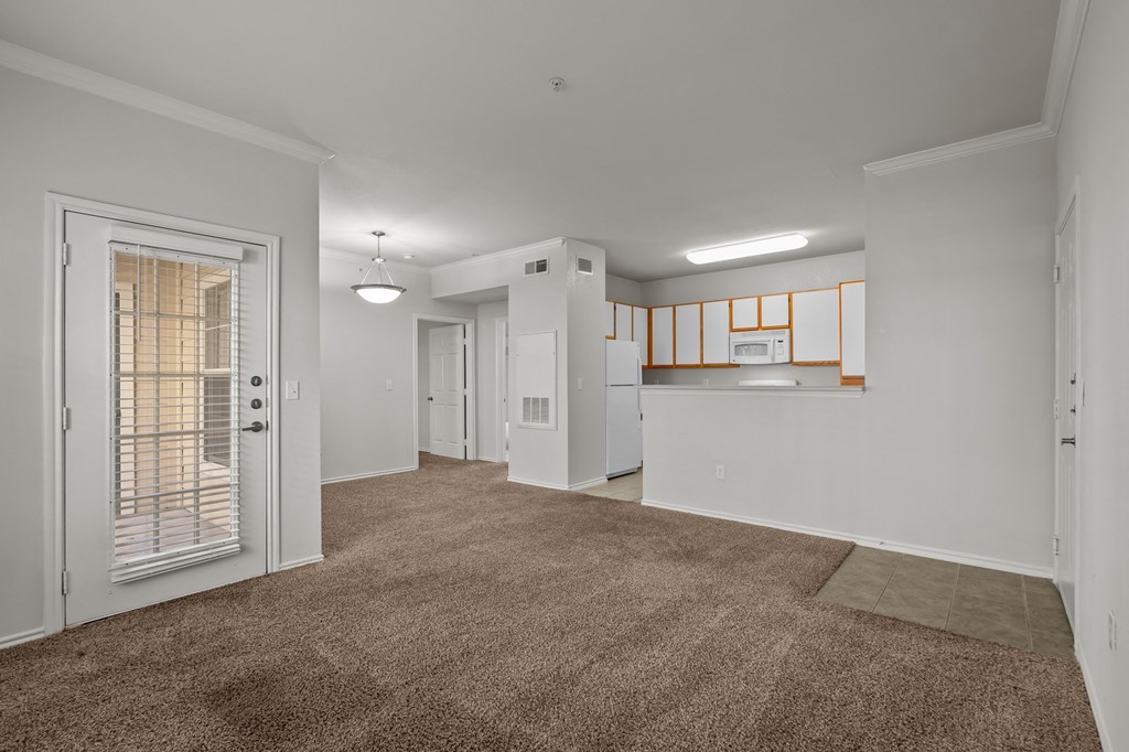 living room and kitchen with white cabinets and a door