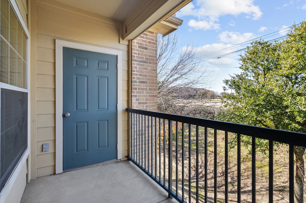 the entrance to a balcony with a blue door and a black railing