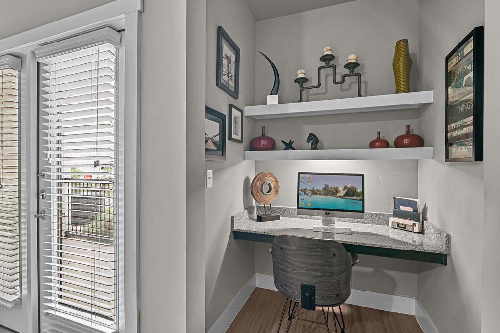 a home office with a computer desk and a window