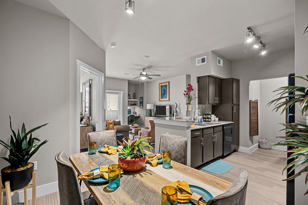 a living room and kitchen with a dining room table and chairs