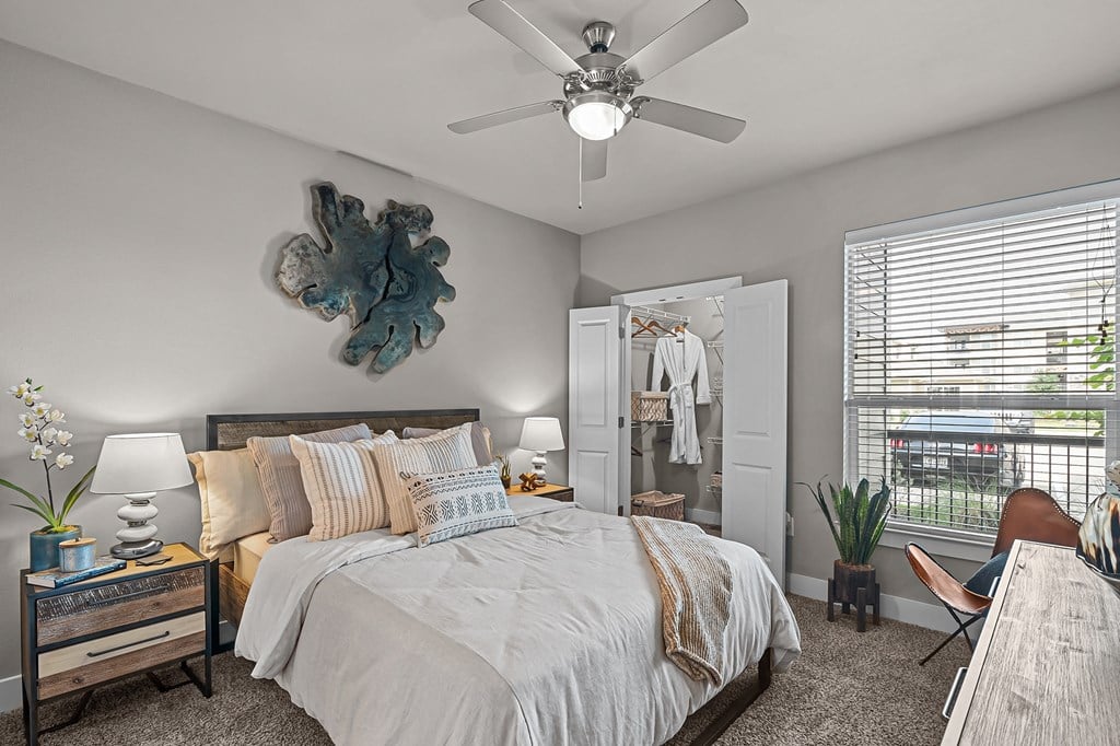 a bedroom with a large bed and a ceiling fan