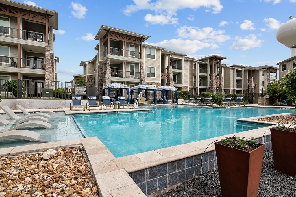 a swimming pool with an apartment building in the background
