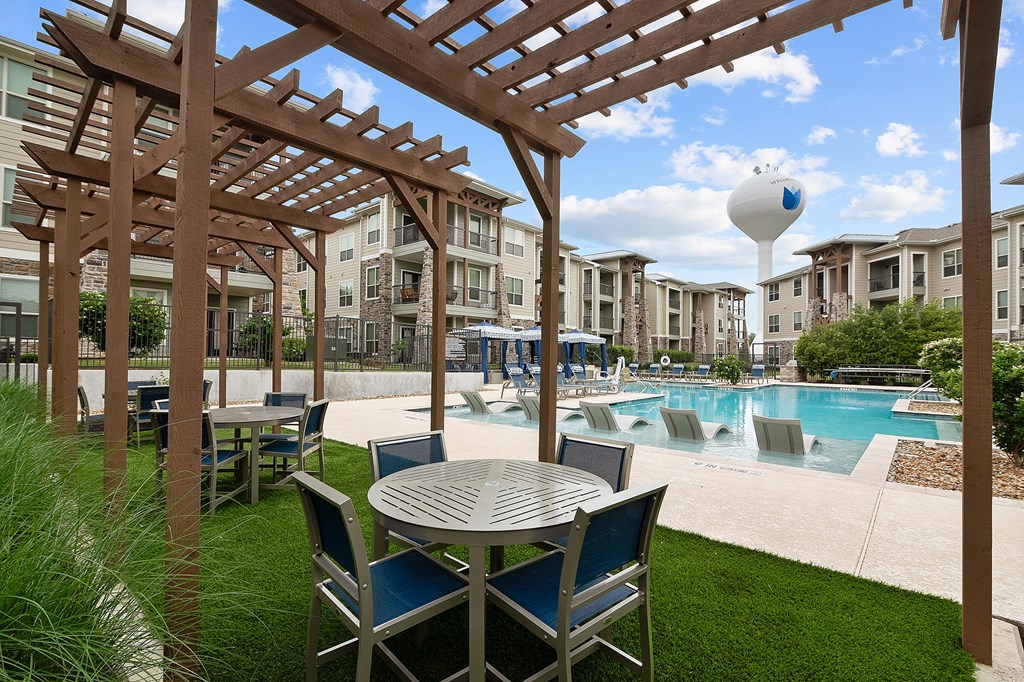 a patio with a table and chairs next to a swimming pool