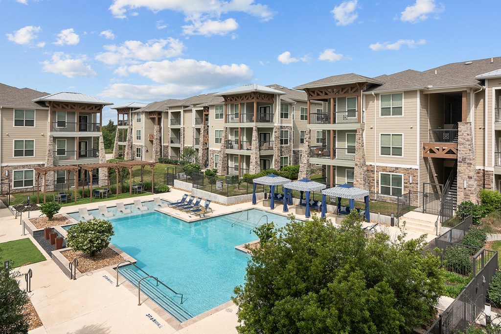 a swimming pool with an apartment building in the background