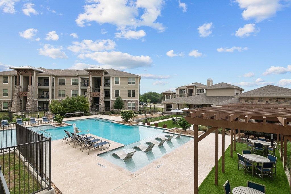 our apartments have a large swimming pool with chairs and tables
