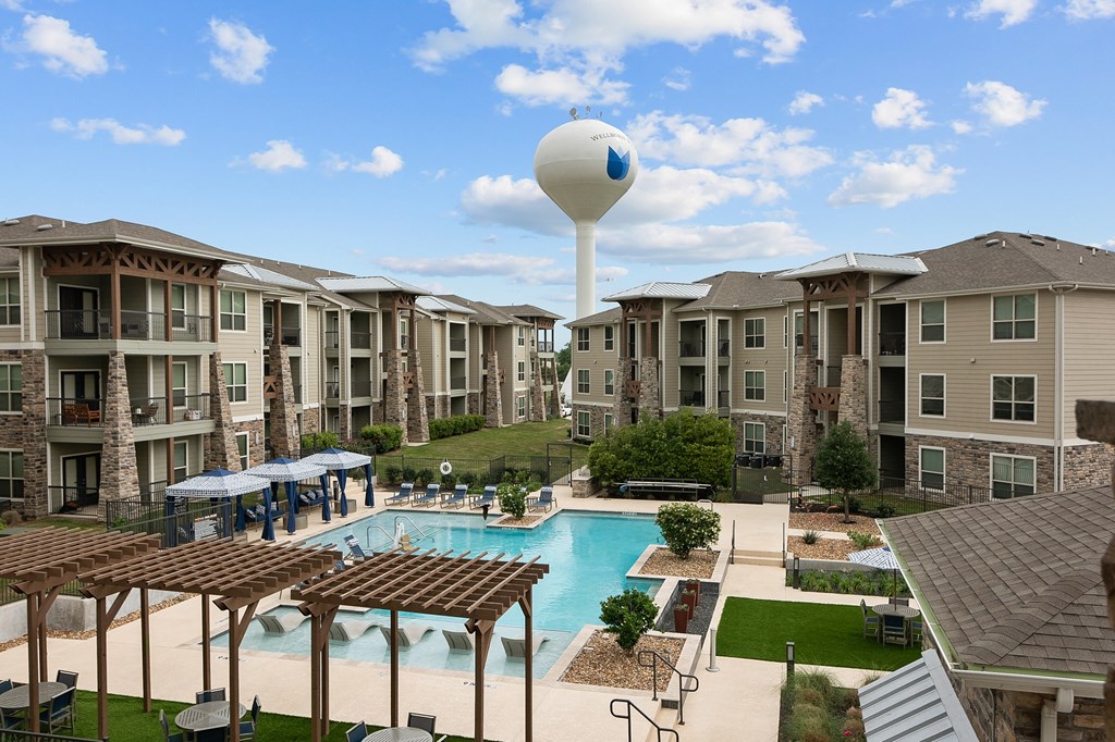 an aerial view of an apartment complex with a pool and water tower