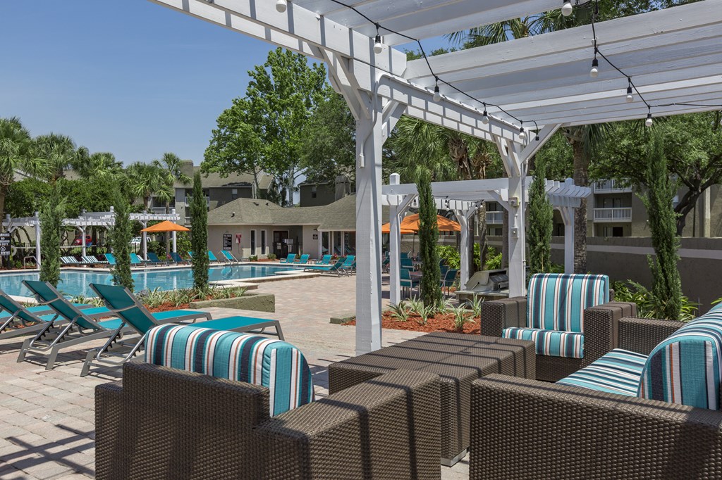 a pool area with lounge chairs and umbrellas