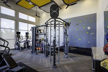 a spacious fitness room with a rock climbing wall