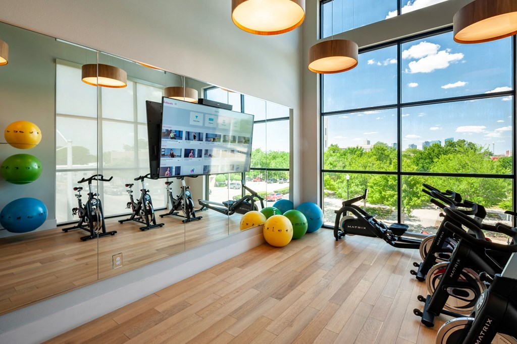 a gym with exercise equipment and windows with a view