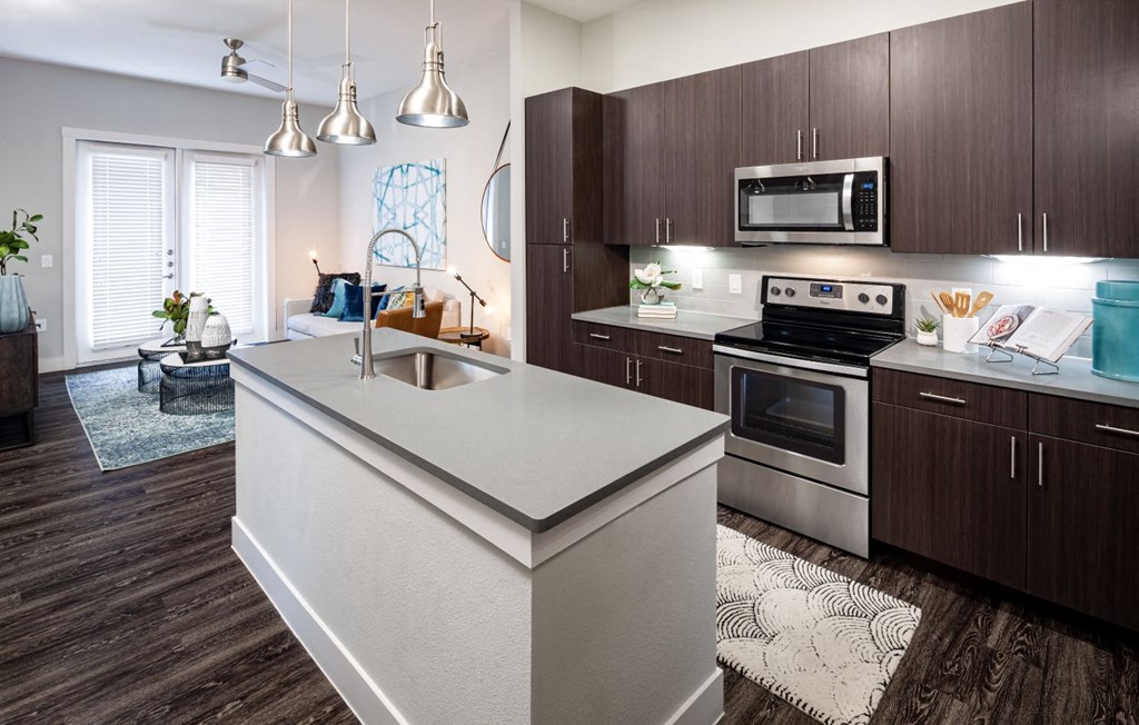 an open kitchen with a large island and stainless steel appliances