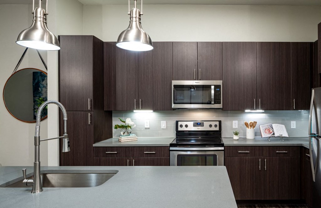 a modern kitchen with dark wood cabinets and stainless steel appliances