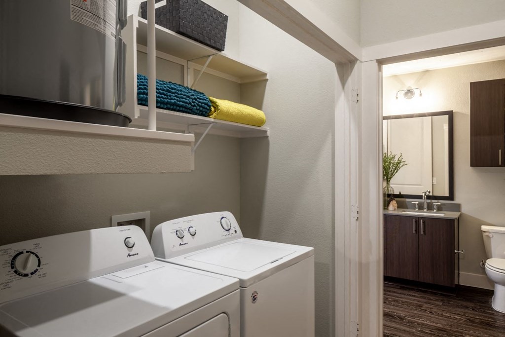 a laundry room with a washer and dryer and a bathroom with a sink