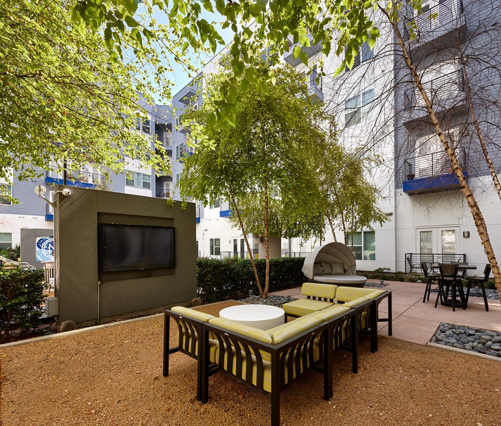 a living room with a tv and a table and a tree