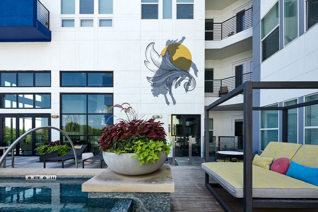a large potted plant in front of a swimming pool
