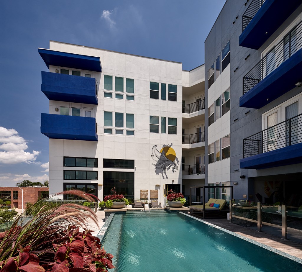 an apartment building with a swimming pool and a mural of a fish