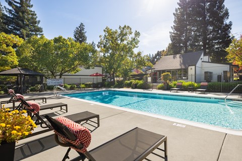 A pool with a table and chairs in front of it.