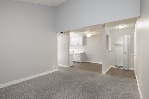 A spacious, empty room with a carpeted floor and white walls.
