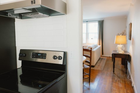 A black stove top oven in a kitchen with a wooden floor.