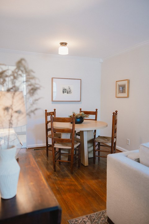 A dining room with a white table and chairs.