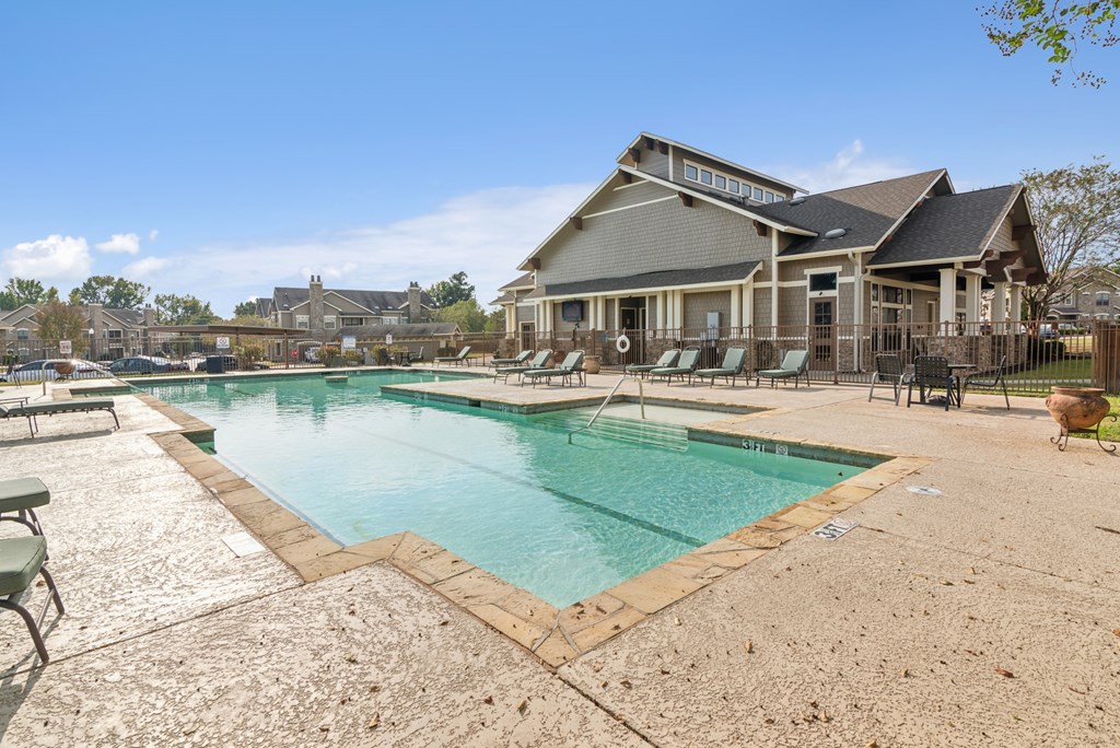 A large swimming pool in front of a house.