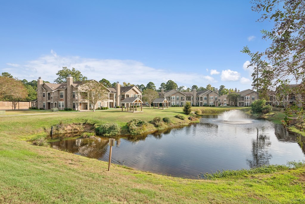 A pond in front of a row of houses.