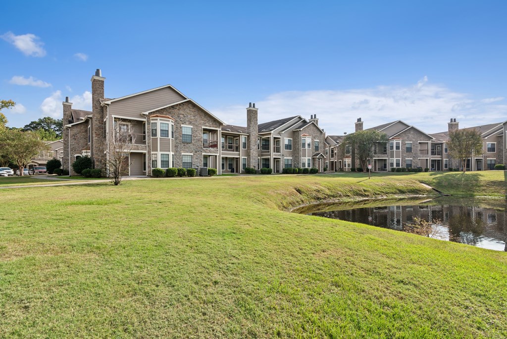 A row of houses with a pond in front.