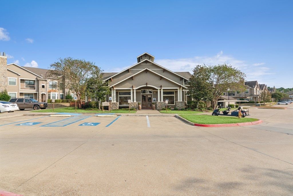 A parking lot with a building in the background and cars parked in the lot.