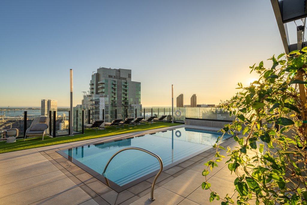 the pool on the rooftop of a building with the city in the background