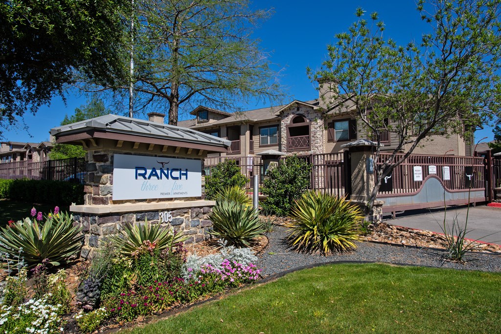 A ranch-style home with a stone sign in front.