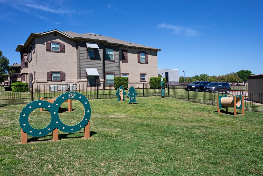 A green sign with two circles on it is in front of a building.