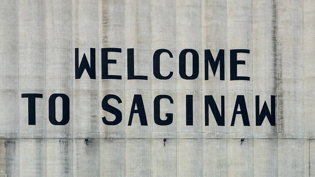 A sign that says "Welcome to Saginaw" is displayed on a wall.