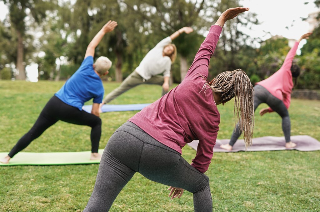 A group of people practicing yoga outdoors.