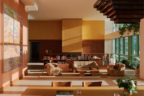 A living room with a large painting on the wall and a coffee table in the center.