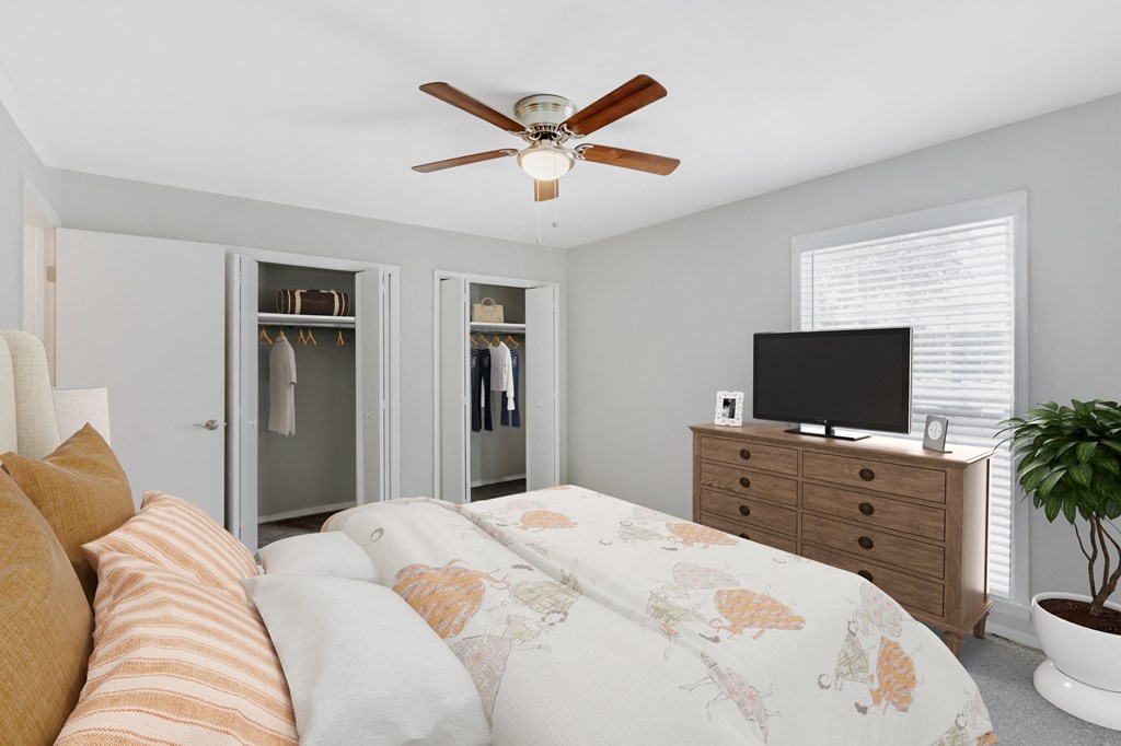 a bedroom with a large bed and a ceiling fan