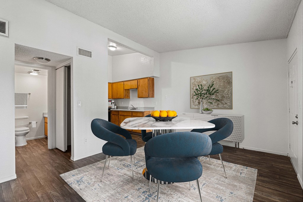 A dining room with a table surrounded by chairs.