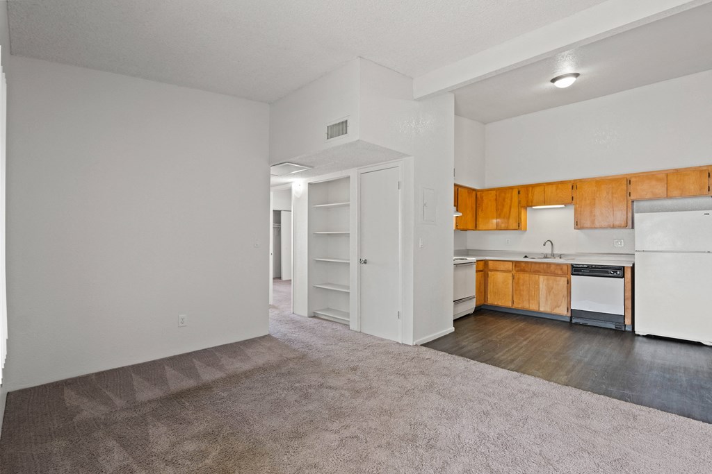 A kitchen with white appliances and wooden cabinets.
