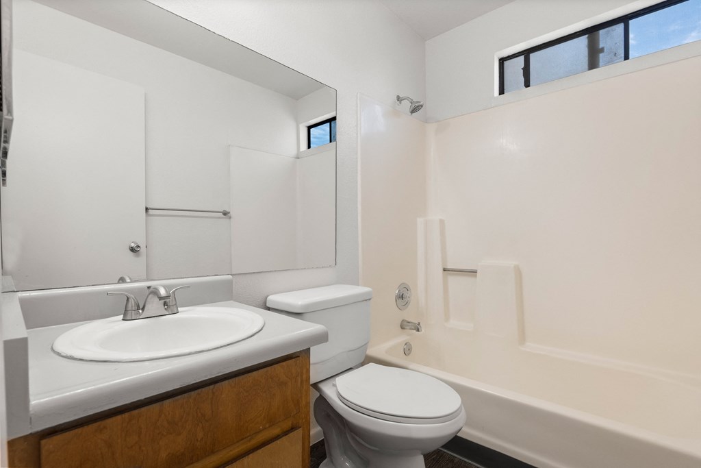 A white bathroom with a toilet, sink, and bathtub.