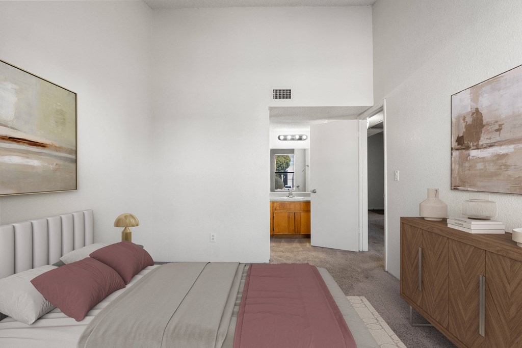 A bedroom with a large bed and a painting on the wall.