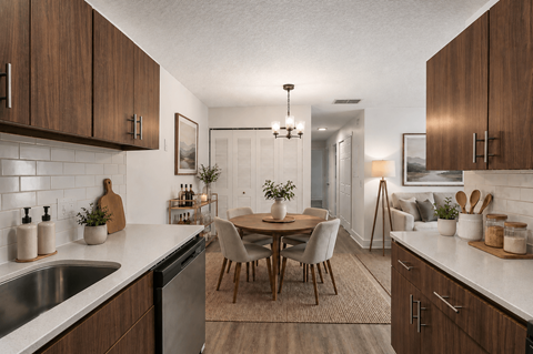 A modern kitchen with wooden cabinets and a dining table.