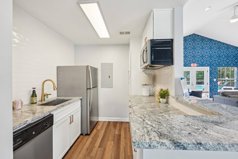 A kitchen with a granite countertop and stainless steel appliances.