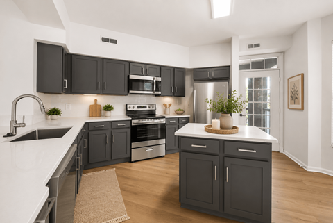 A modern kitchen with dark grey cabinets and white countertops.