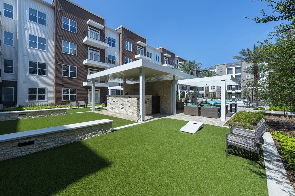 a courtyard with a lawn and a pavilion with a pool