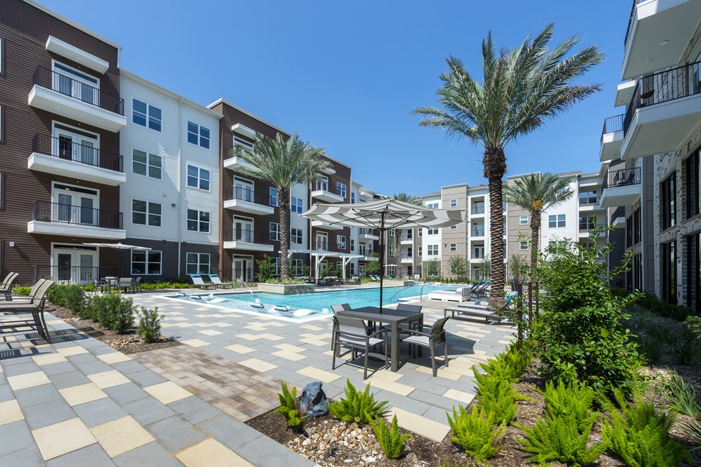 pool with patio furniture and landscaping