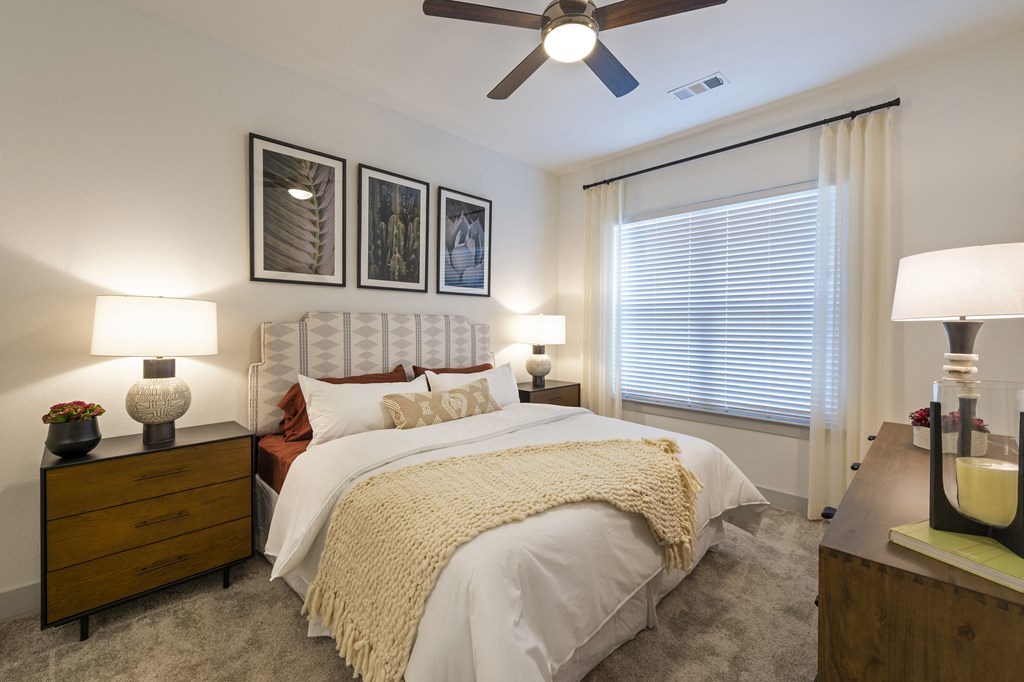a bedroom with a large bed and a ceiling fan