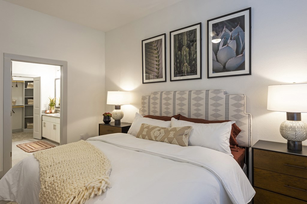 a bedroom with a bed and pictures on the wall