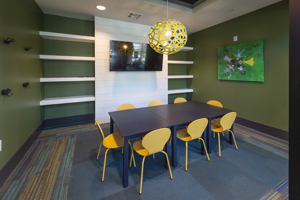 a dining room with a black table and yellow chairs