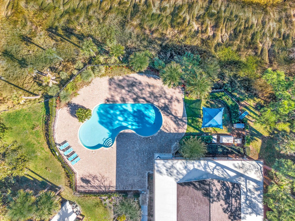 an aerial view of a pool and a house with a blue pool