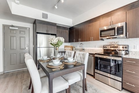 a kitchen and dining room with stainless steel appliances and a table