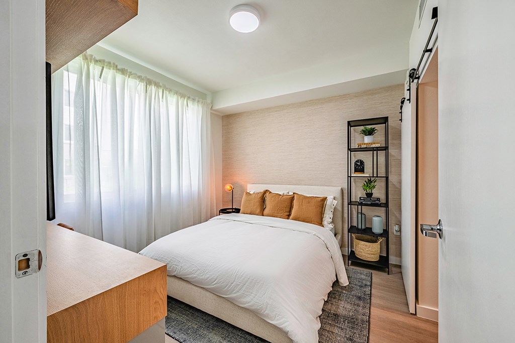 A bedroom with a large bed and a wooden headboard.